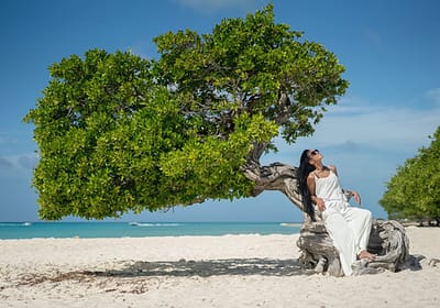 Woman reclining on a divi-divi tree in Aruba