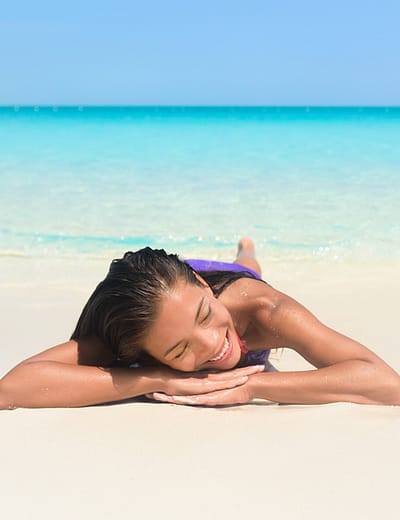 Woman relaxing on Grace Bay Beach