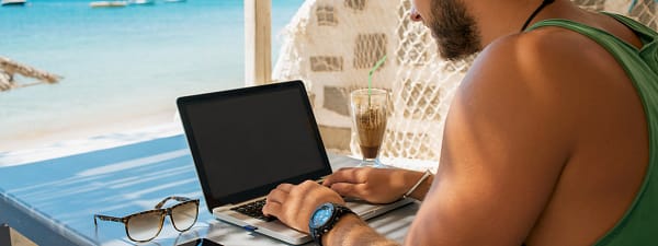 Man with laptop by the beach