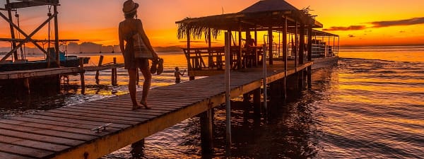 Woman on a pier in Roatan at sunset